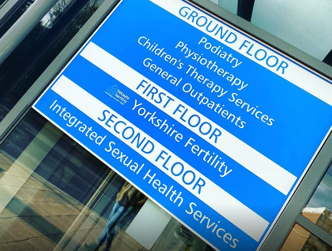 A blue floor plan sign with white and blue text.