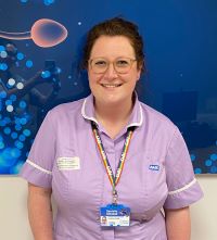 A person with brown eyes wearing glasses, light brown hair, and a purple uniform.