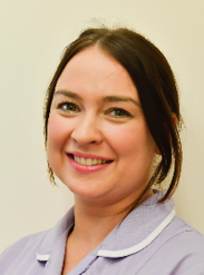 A person with brown eyes, brunette hair tied back, and a purple uniform.