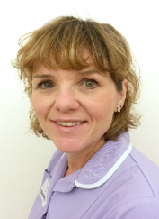 A person with light brown hair with a fringe, and a purple uniform.