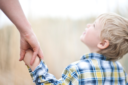 Boy holding hands with adult