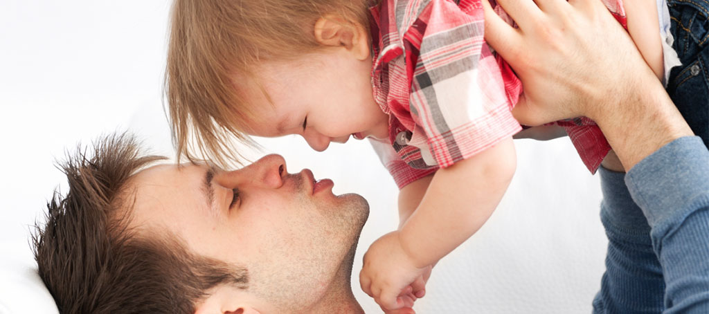 Male holding child in the air