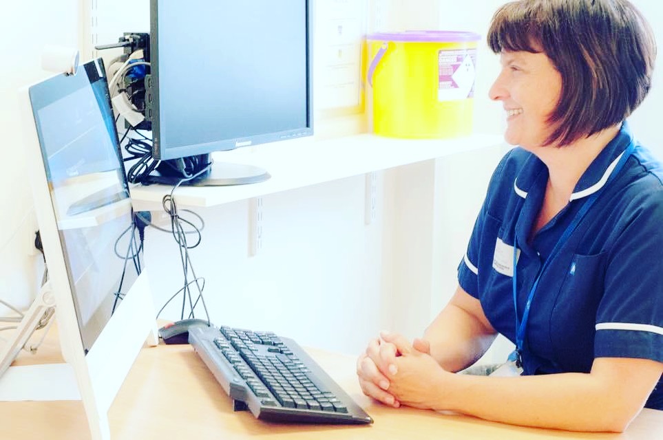 Nurse looking at a virtual conferencing unit screen